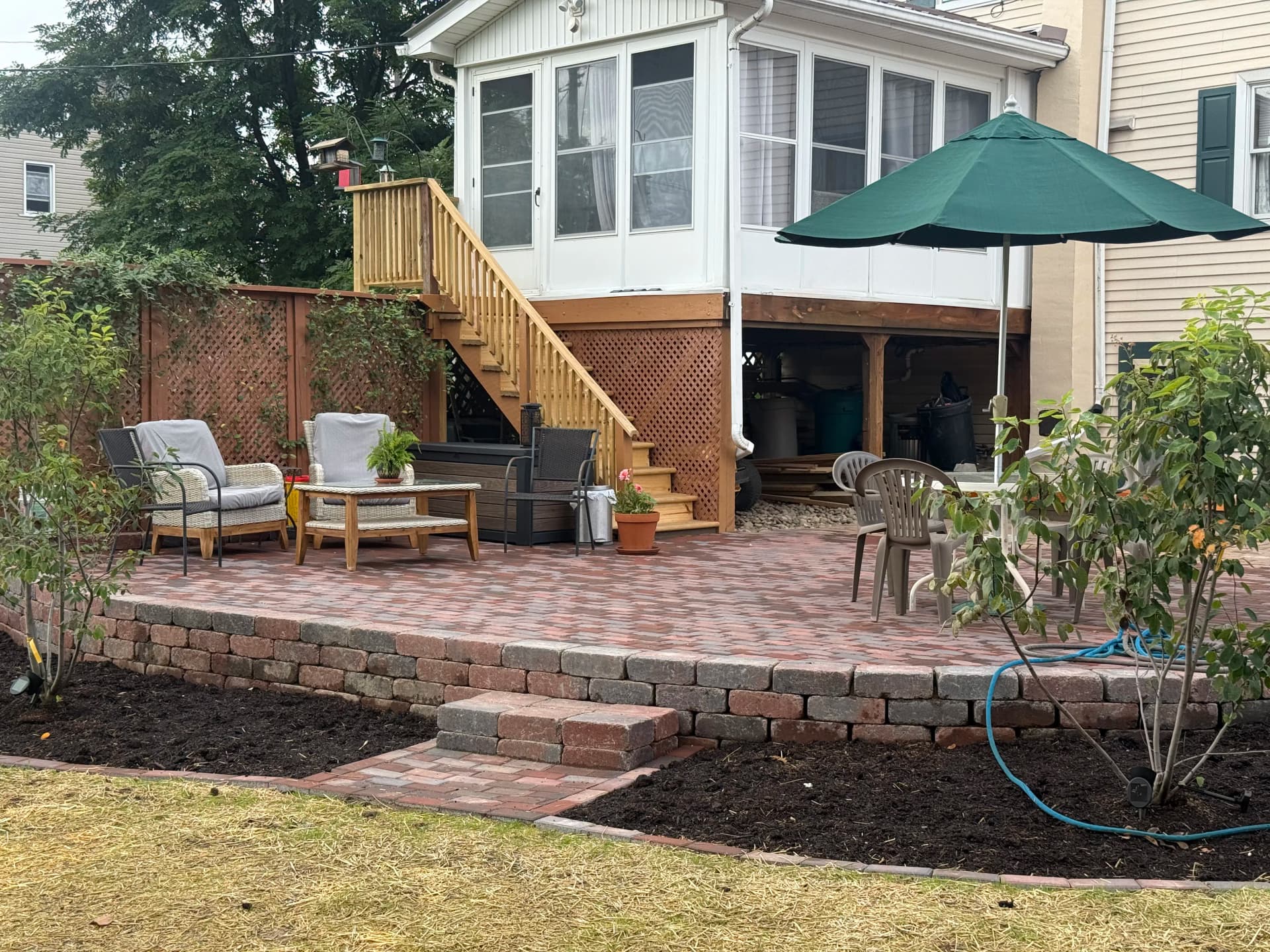 Paver Patio With Retaining Wall and Fresh Planting Beds